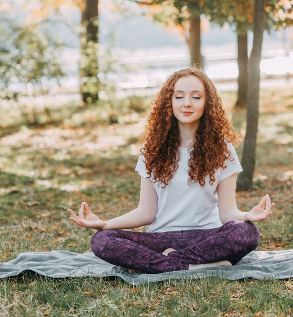 Person meditating peacefully in a serene natural setting.